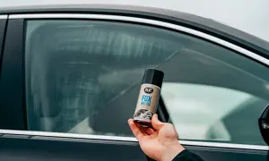 Dłoń trzyma puszkę preparatu K2 FOX ANTI-FOG, który zapobiega parowaniu szyb w samochodzie.