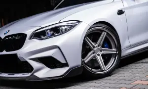 Srebrne auto z chromowanymi felgami o wieloramiennym wzorze i niebieskimi zaciskami hamulcowymi. Idealne felgi do srebrnego auta? Te wyglądają świetnie!