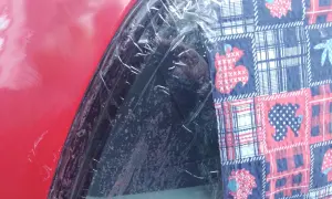 Czerwony lakier samochodu z folią ochronną i kolorową tkaniną z motywem zwierząt. To dowód, że lakierowanie samochodu zrób to sam może być kreatywne.