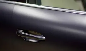 Matowa, ciemna karoseria samochodu z elegancką, chromowany kolor klamką.