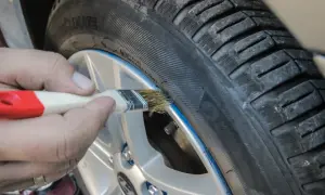 Ręczne malowanie felgi pędzlem, pokazujące zastosowanie gumy w sprayu do tuningu wizualnego opon.