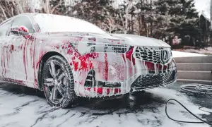 Czerwony samochód pokryty pianą, gotowy do mycia. Odpowiedź na pytanie: czy można myć auto w zimie? Tak, jeśli użyjesz odpowiednich środków.