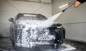Czarny Lexus w myjni bezdotykowej. Woda i piana spływają po masce i grillu. Poznaj myjnia bezdotykowa triki, by Twój samochód lśnił!