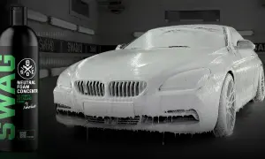 Luksusowe auto pokryte obfitą, rozrabianą aktywną pianą, gotowe na dokładne mycie. Obok butelka koncentratu SWAG.