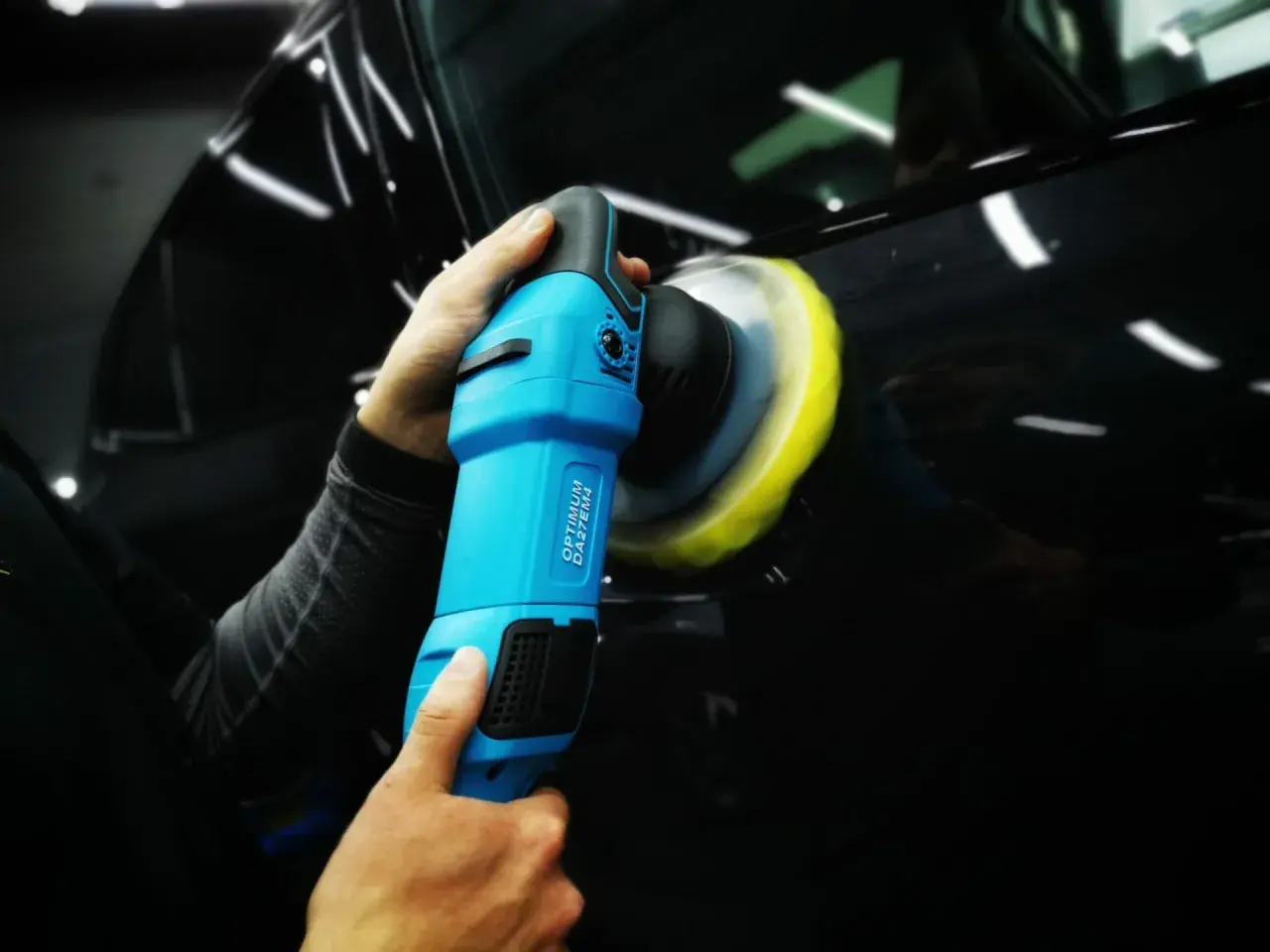 Profesjonalna renowacja lakieru samochodowego przy użyciu polerki. Błyszczące auto po zabiegu.