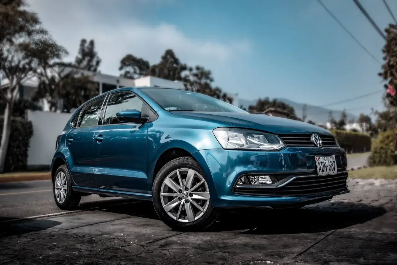 Niebieski samochód Volkswagen Polo zaparkowany na zewnątrz.