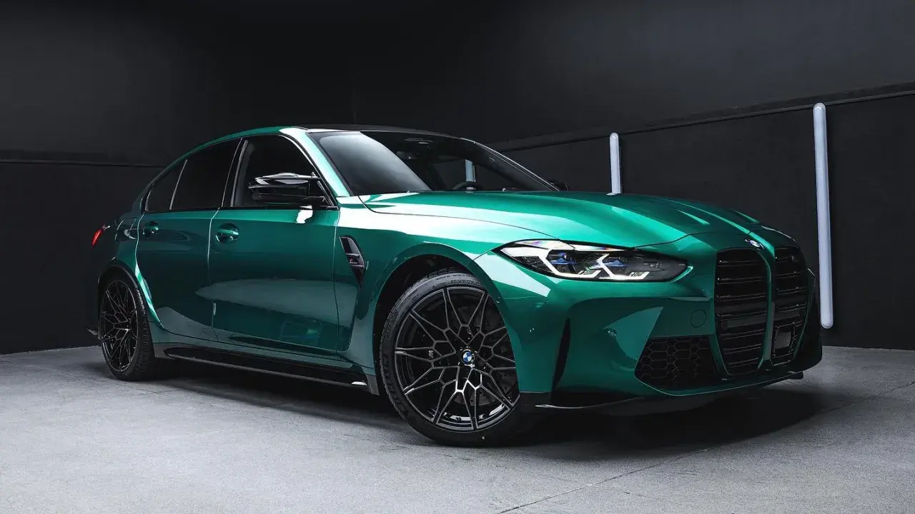Błyszczący, sportowy sedan w kolorze midnight green, z czarnymi felgami i agresywnym przodem, gotowy na nocne wyścigi.