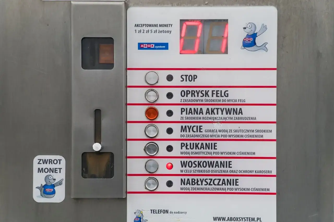 Panel myjni samochodowej z przyciskami: stop, oprysk felg, piana aktywna, mycie, płukanie, woskowanie, nabłyszczanie. Instrukcja jak myć auto na myjni.