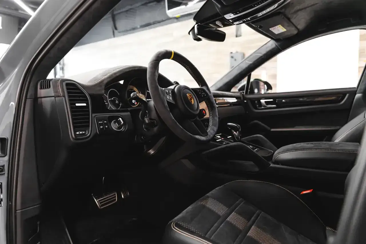 Wnętrze Porsche Cayenne po oklejaniu dekor&oacute;w. Sk&oacute;rzana kierownica, sportowe fotele i nowoczesny kokpit.